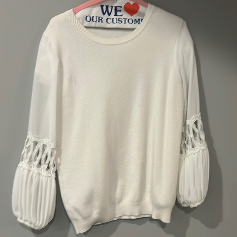 Beautiful white sweater with embellished long sleeves. Good condition.